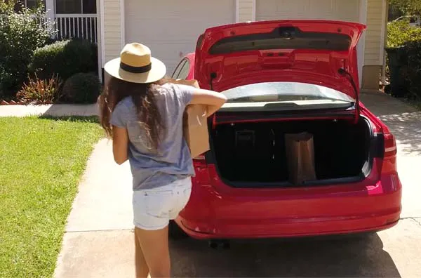 Woman removing items from a trunk