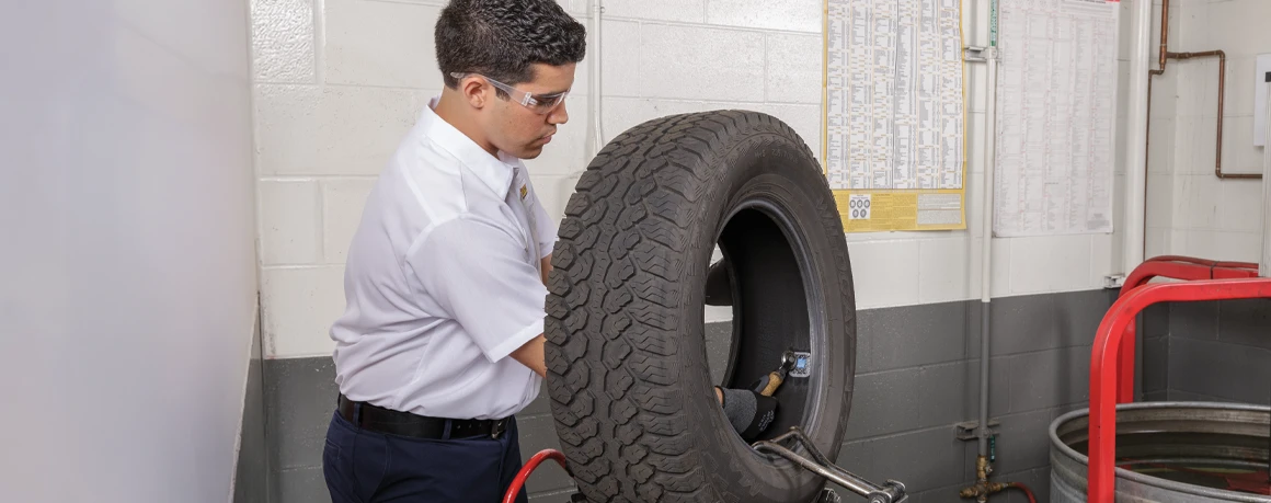 Les Schwab employee inspects a tire