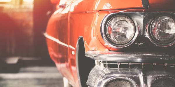 A red classic car in a garage.