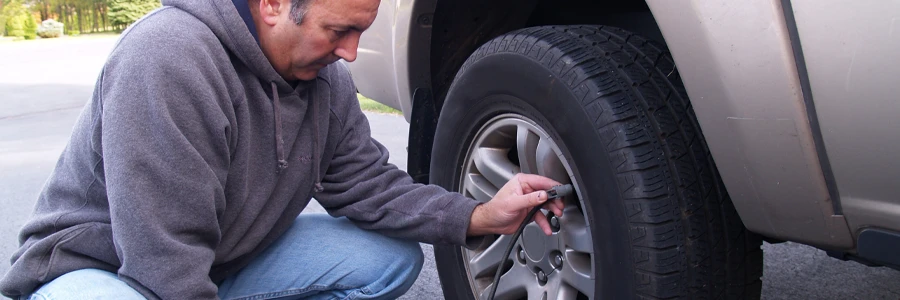 Person adds air to their vehicle’s tire to bring it to the proper air pressure