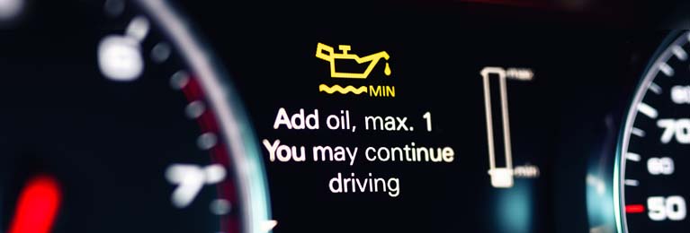 Low oil light illuminated on car dash.