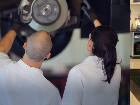 Two Les Schwab technicians examine one of the calipers of a car while it’s on a lift.