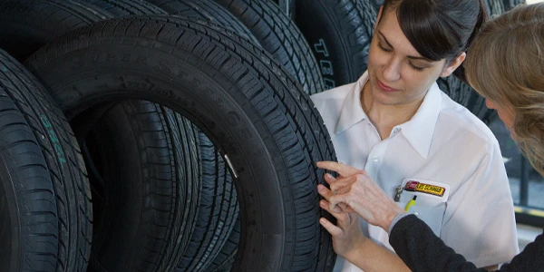 A Les Schwab tire expert explains tire tread and more to a customer