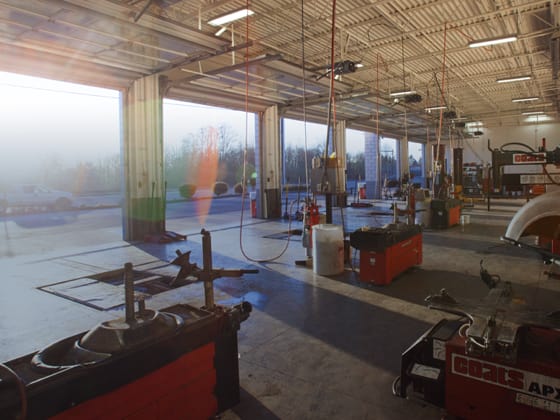 The inside of a wide Les Schwab garage, with all doors open.