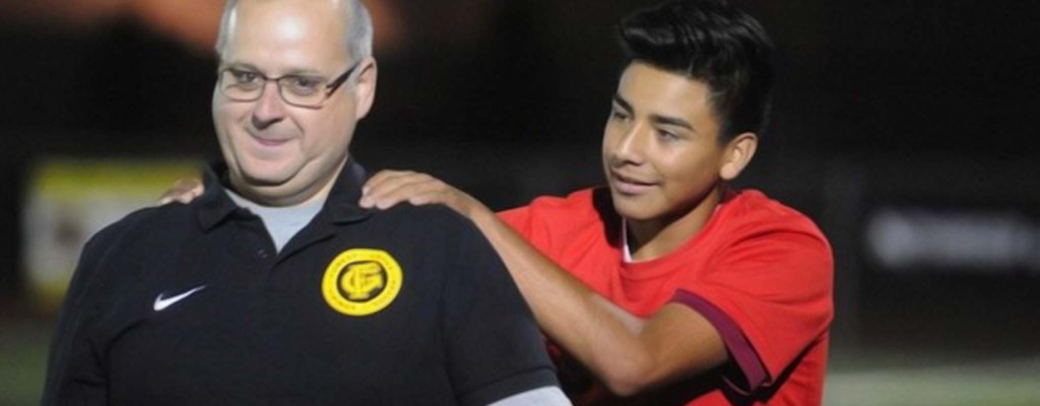 Forest Grove boys soccer coach, Angelo Simonetti gets patted on the back by one of his players.