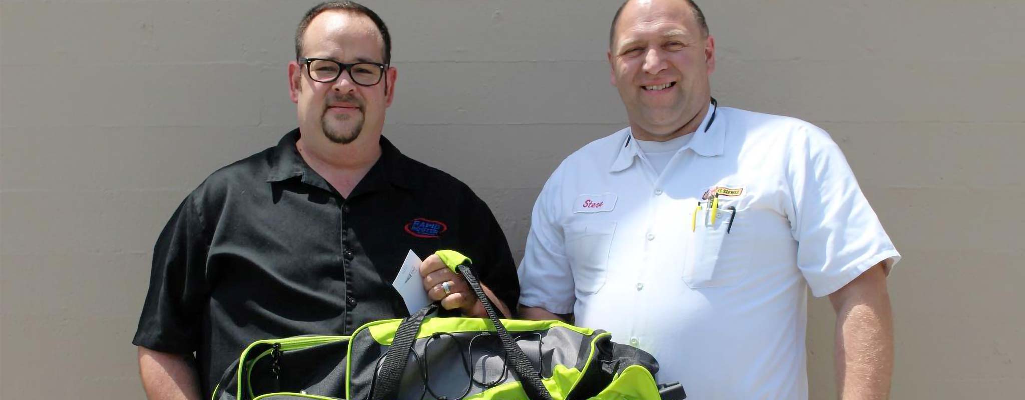 Mike stands next to a Les Schwab manager.