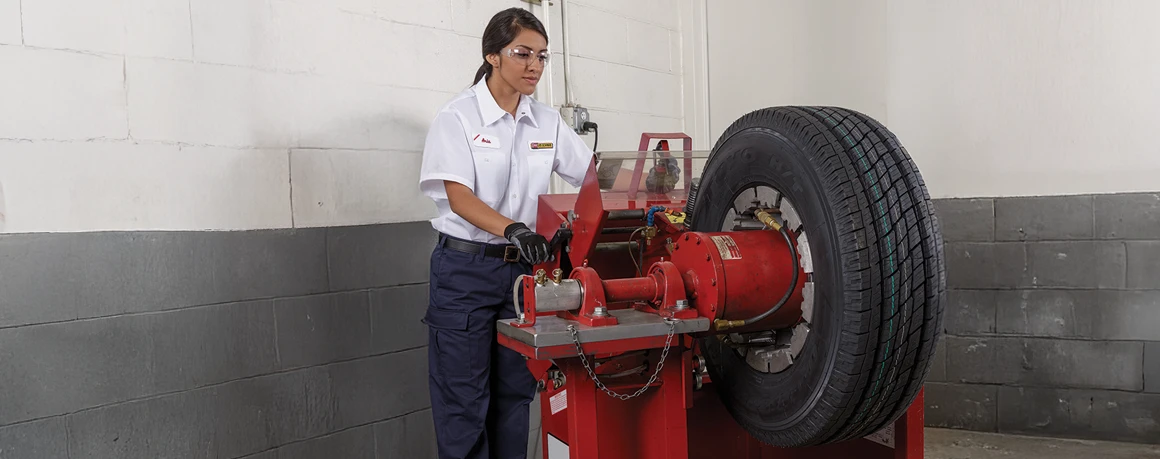 Les Schwab employee using a siping machine to add sipes to a tire