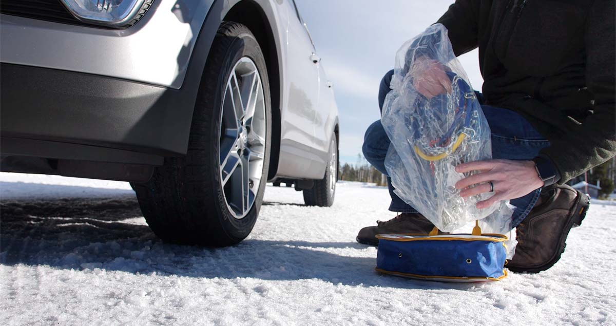 Man removing tire chains from the storage case.