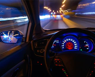 View of car and street lights through a windshield.