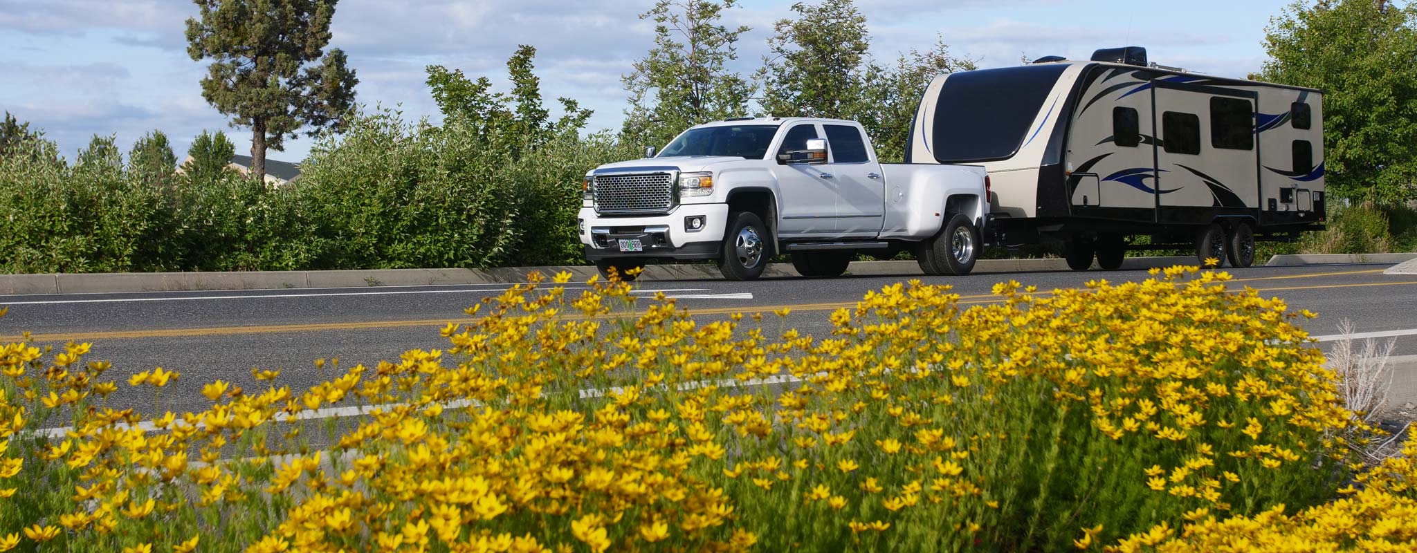 White truck pulling a long travel trailer.