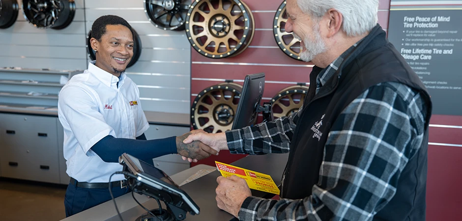 Les Schwab employee shaking a customer's hand