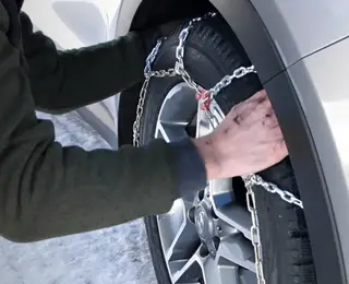 Man installing quick fit snow chains