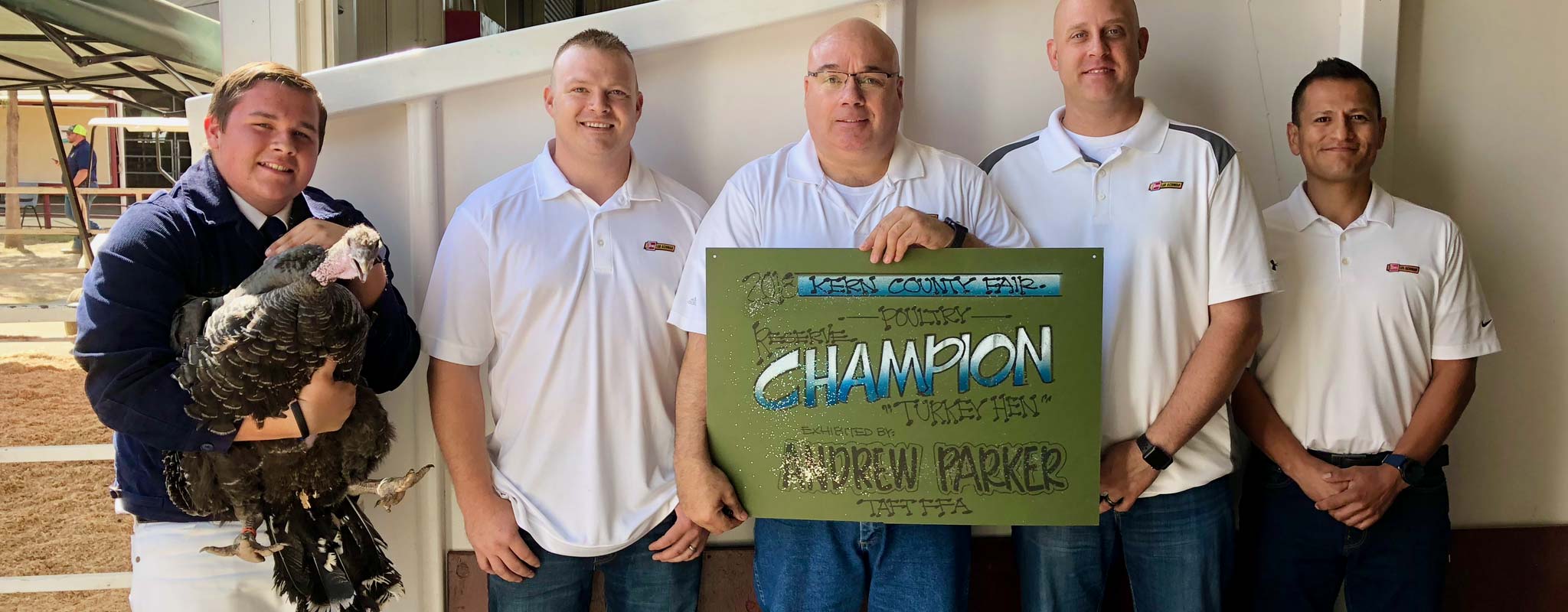 Bakersfield Les Schwab managers pose with Andrew Parker and his Reserve Champion Turkey Hen.