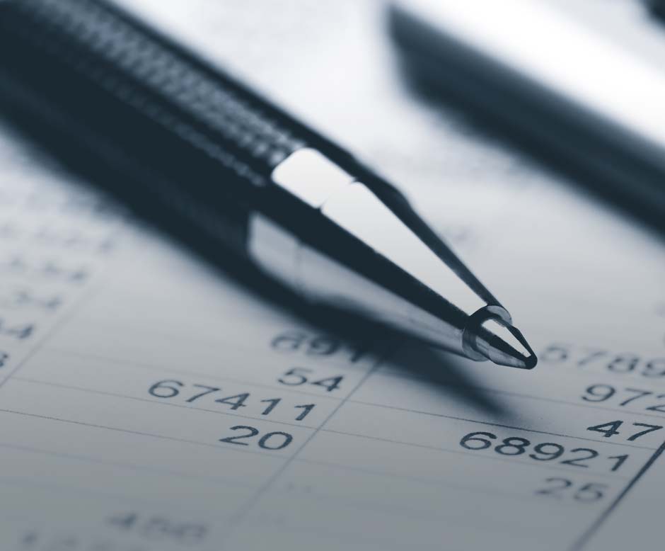 Pen and calculator over ledger book