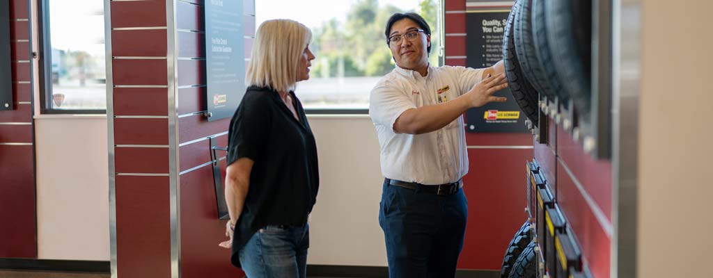 Les Schwab employee showing a woman tires