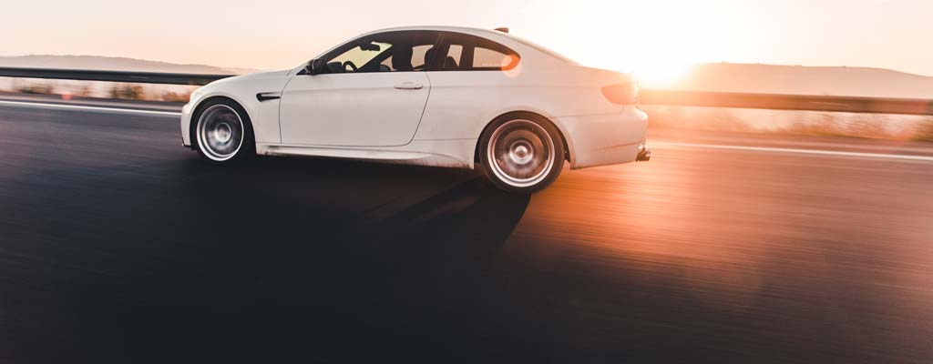Luxury car on road during sunset