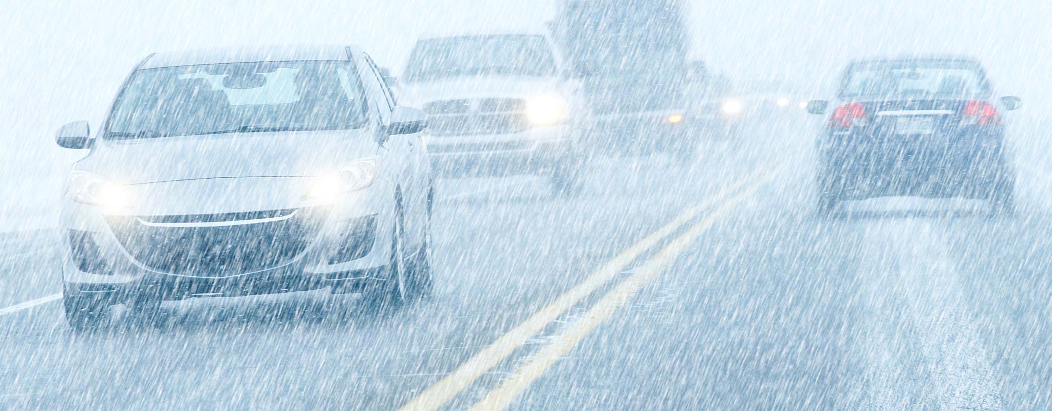 Cars on a driving through snowy weather.