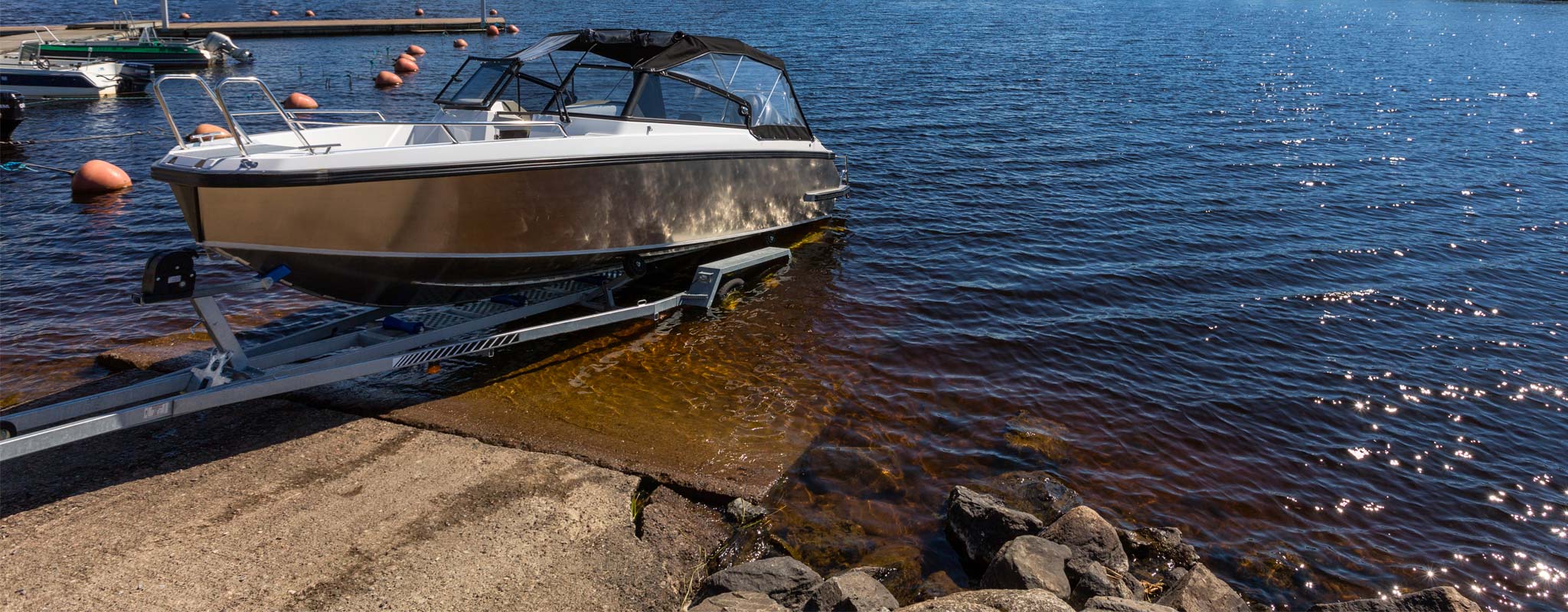 Aluminum motor boat on a trailer at a boat launch