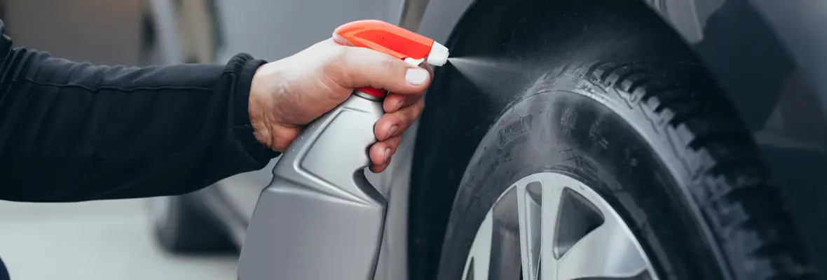 Spraying a tire cleaner on tires