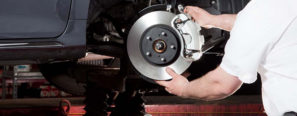Mechanic working on a vehicle's brakes.