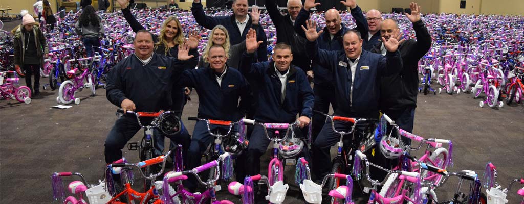 Les Schwab employees in a room full of children’s bikes that they helped assemble.