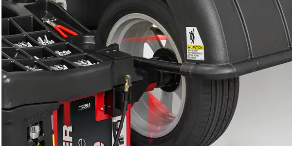 A tire and wheel set mounted on a tire balancing machine.