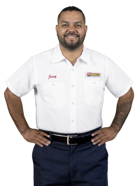 A Les Schwab technician stands arms akimbo. His name is Jessy